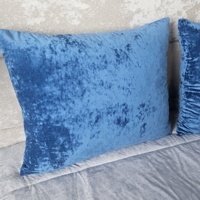 Almofada retangular azul em veludo com textura semelhante em cama cinza