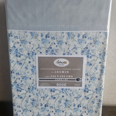 Jogo de cama estampado com flores azuis e etiqueta com informações do produto