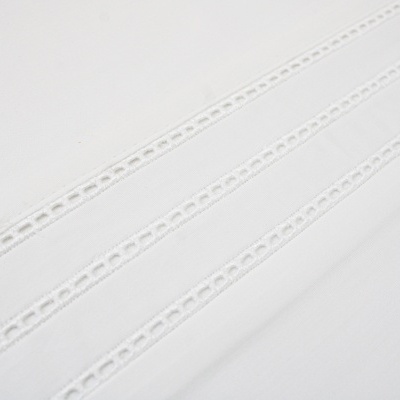 Tecido branco com faixas decorativas perfuradas
