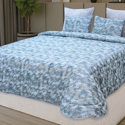 Conjunto de cama com edredão e almofadas padrão azul e bege numa divisão moderna