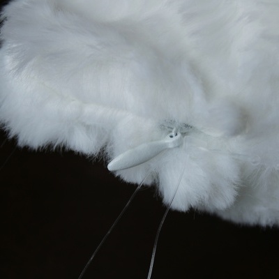 Pano de limpeza branco peludo com ponteira branca e fios transparentes sobre fundo preto