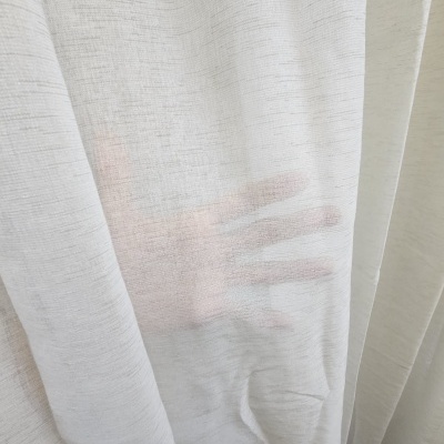 Cortina branca transparente com uma mão visível atrás