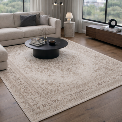 Sala de estar com sofá bege, mesa de centro preta e tapete decorativo bege com padrão floral.