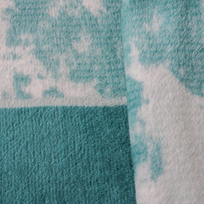 Toalha azul e branca com padrão pixelizado e textura felpuda.