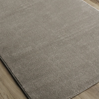 Tapete cinza claro sobre chão de madeira clara