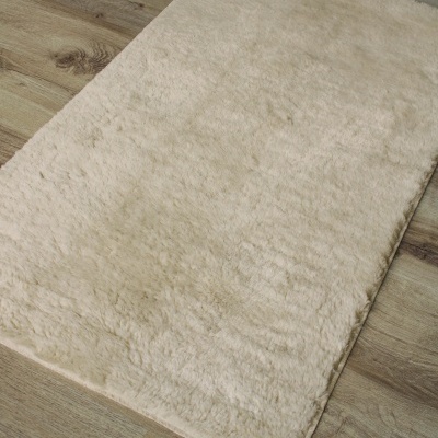 Tapete creme felpudo sobre chão de madeira clara