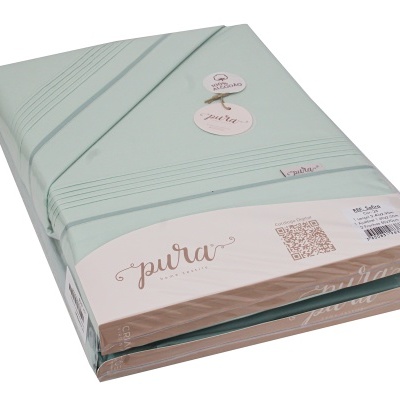 Conjunto de lençóis verde claro embalado com etiquetas da marca pura e informações de algodão.