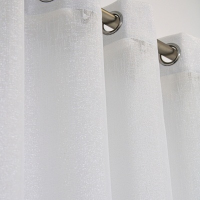 Cortina branca translúcida com ilhóses prateados pendurada numa barra metálica.