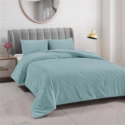 Cama com colcha e almofadas azuis acolchoadas em quarto com parede branca e espelho redondo