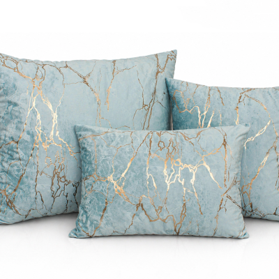 Três almofadas azuis com padrão dourado sobre fundo branco