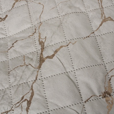 Tecido acolchoado cinzento claro com padrão dourado brilhante e costura em pontos