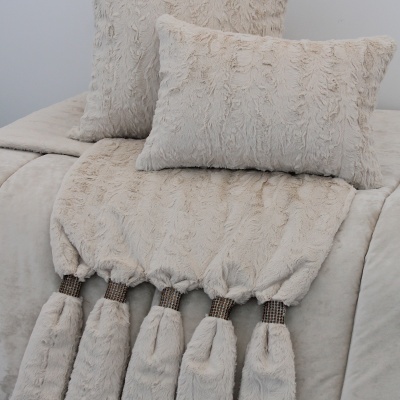 almofadas peludas e manta bege com tasséis