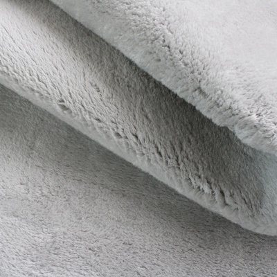 Tapete cinzento claro felpudo com textura macia e dobra visível