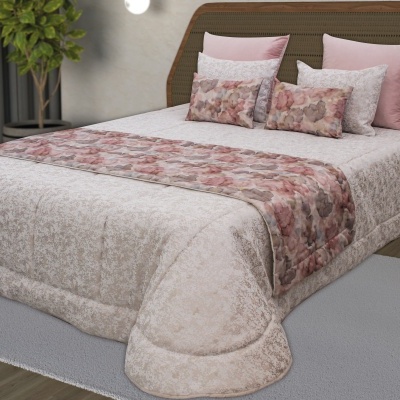 Conjunto de cama com almofadas cor-de-rosa, bege, e padrão abstrato, coberto com cobreleito bege e passadeira floral.