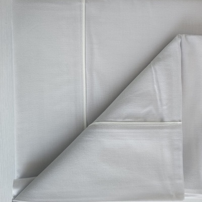 Guardanapo ou pano de tecido branco com costuras e detalhes em linha branca.