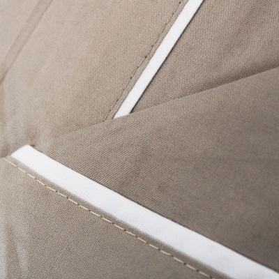 Tecido cinzento-bege com costuras brancas em close-up
