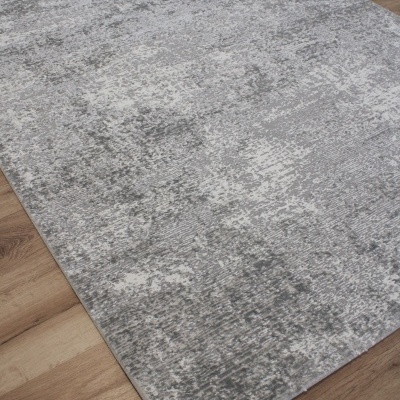 Tapete cinzento abstrato sobre piso de madeira