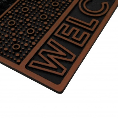 Tapete de entrada castanho e preto com texto Welcome em relevo