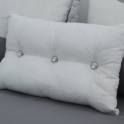 Almofada branca decorativa com botões sobre sofá cinza
