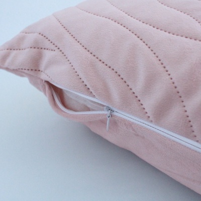 Almofada rosa com padrão ondulado e fecho de correr