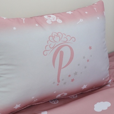 Almofada retangular com padrão rosa e branco, letra P com coroa
