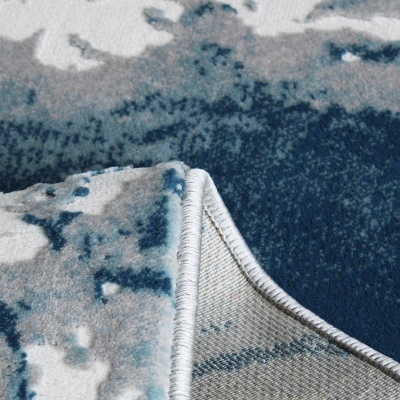 Tapete azul, cinza e branco com padrão abstrato e bordas cosidas