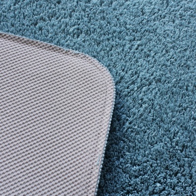 Tapete azul macio com base cinza anti-derrapante em close-up