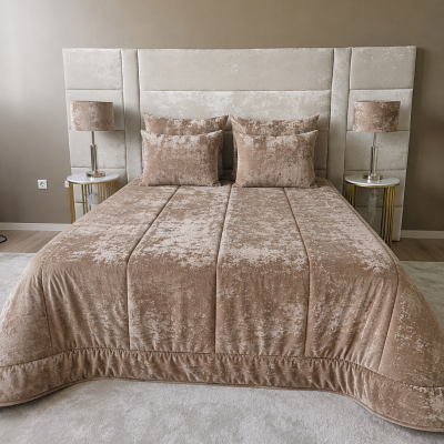 Cama de casal com edredão e almofadas cor de bronze aveludadas e cabeceira beige estofada