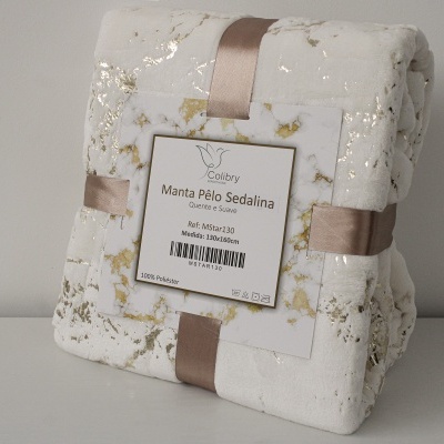 Manta branca com padrão marmoreado dourado em embalagem com fita cor de rosa e etiqueta
