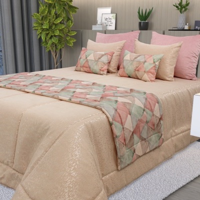 Cama arrumada com colcha bege e almofadas cor-de-rosa e bege, cobertor geométrico colorido