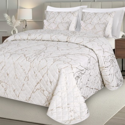 Conjunto de cama branco com padrão marmoreado dourado numa cama com cabeceira bege e mesa de cabeceira de madeira
