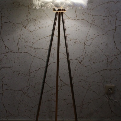 Candeeiro de pé com base tripé de madeira e cúpula de penas brancas iluminado
