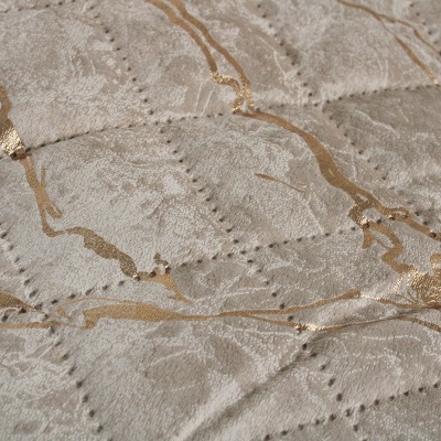 Tecido matelassado cinzento com linhas douradas entrelaçadas