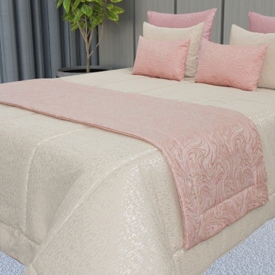 Colcha bege com manta rosa floral e almofadas em cama numa divisão moderna