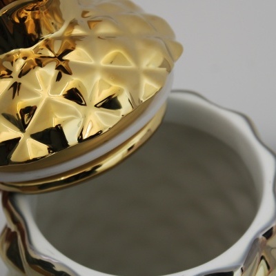 Pote decorativo branco com tampa dourada em relevo