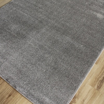 Tapete cinza de pelo curto sobre chão de madeira clara