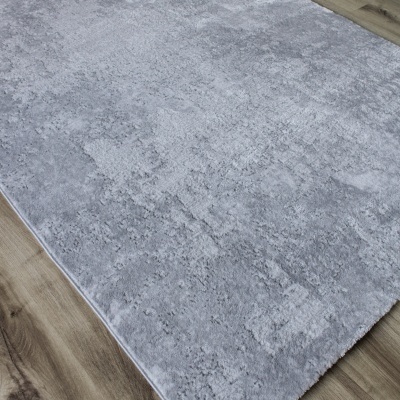 Tapete cinza texturizado sobre chão de madeira clara