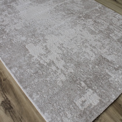 Tapete cinza-bege com padrão abstrato sobre chão de madeira clara