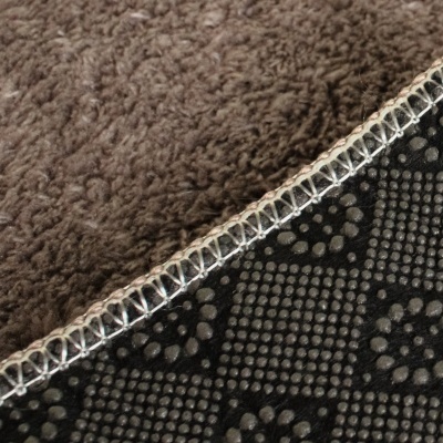 Manta com lado macio castanho e lado antiderrapante preto com padrão de pontos