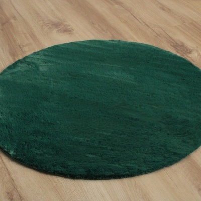 Tapete redondo verde escuro em chão de madeira clara