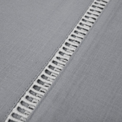 Tecido cinzento com faixa decorativa em malha aberta.