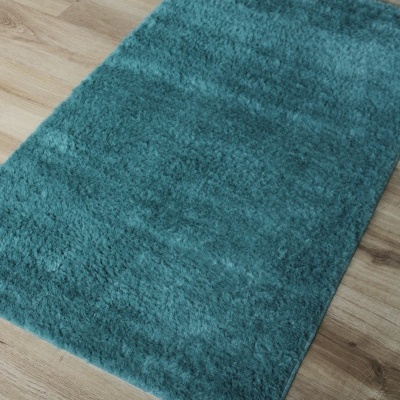 tapete azul turquesa sobre chão de madeira clara