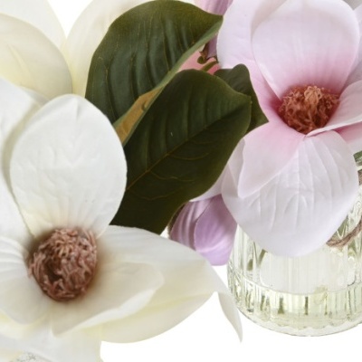 Flores artificiais brancas e cor-de-rosa em jarros de vidro com folhas verdes