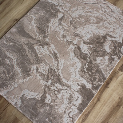 Tapete abstrato cinzento e bege sobre chão de madeira clara