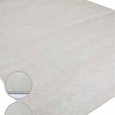 Tapete cinzento claro com textura felpuda e detalhes das bordas e verso