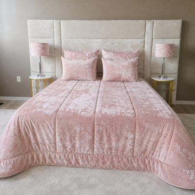 Quarto com cama e roupa de cama rosa, mesa de cabeceira branca com pernas douradas e abajur rosa