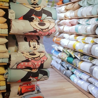 Edredons com estampas Mickey Mouse e Relâmpago McQueen numa loja organizada