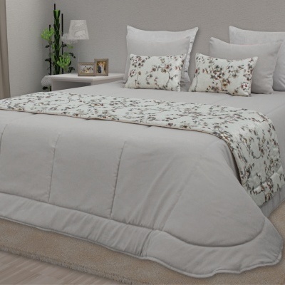 Conjunto de cama cinzento com almofadas e manta floral em quarto decorado
