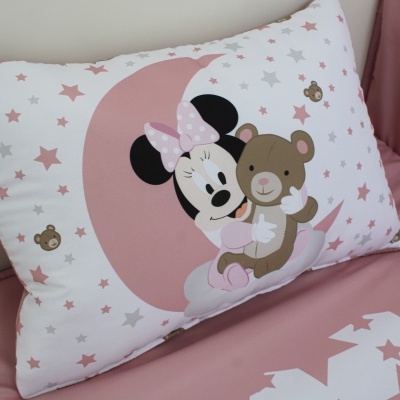 Travesseiro decorativo com estampa da Minnie e ursinho em fundo branco com estrelas e lençol rosa