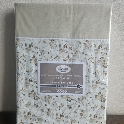 Jogo de cama estampado com barra aplicada Jasmin em embalagem plástica.